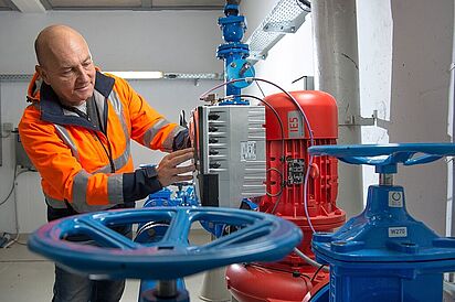 MIDEWA-Mitarbeiter bei der Prüfung einer Pumpe zur automatischen Druckausgleichung