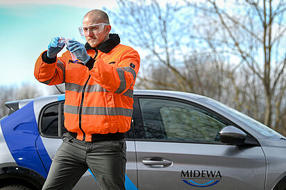 Ein Midewa-Mitarbeiter hat eine Wasserprobe an einer Entnahmestelle entnommen.
