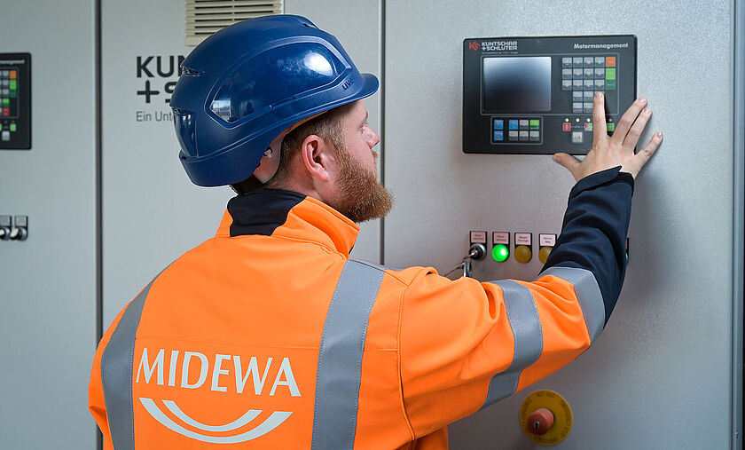 Das Bild zeigt einen Mitarbeiter am Schaltschrank. 