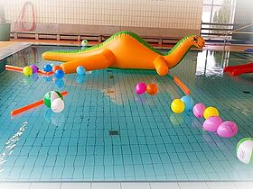 gelbes Grosswasserspielzeug als Dinosaurier schwimmt im Nichtschwimmerbecken der Schwimmhalle Gräfenhainichen 