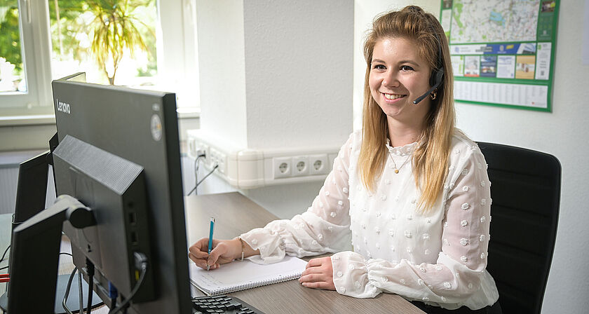 Eine Kundenservice-Mitarbeiterin arbeitet am Rechner. 